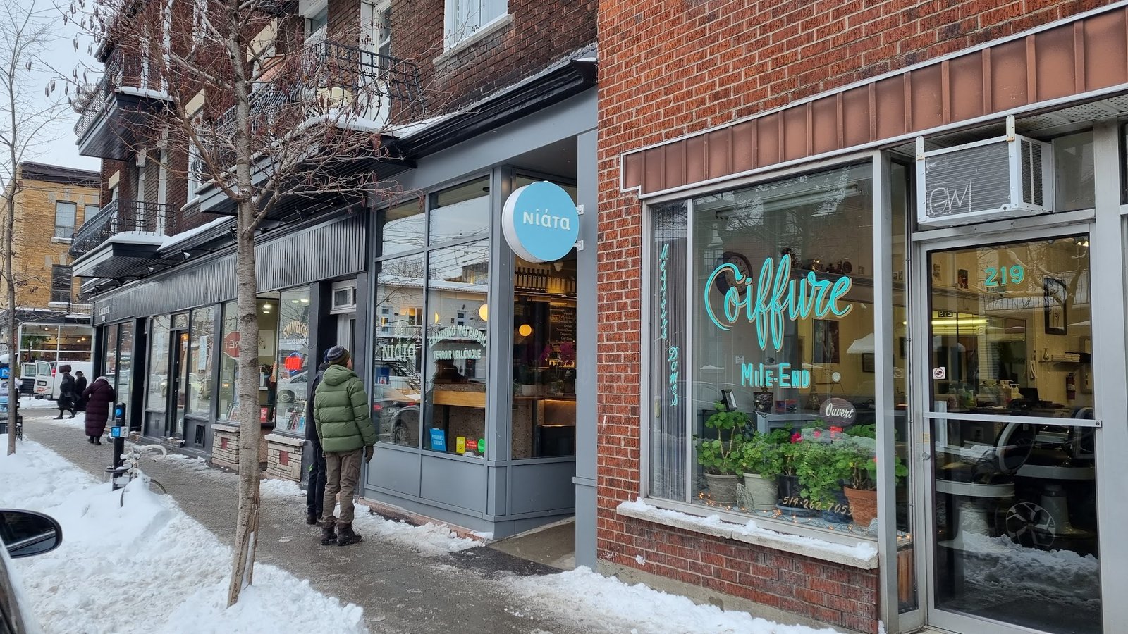 Devanture de Coiffure Mile-End sur la rue Saint-Viateur en hiver, enseigne verte dans la vitrine.